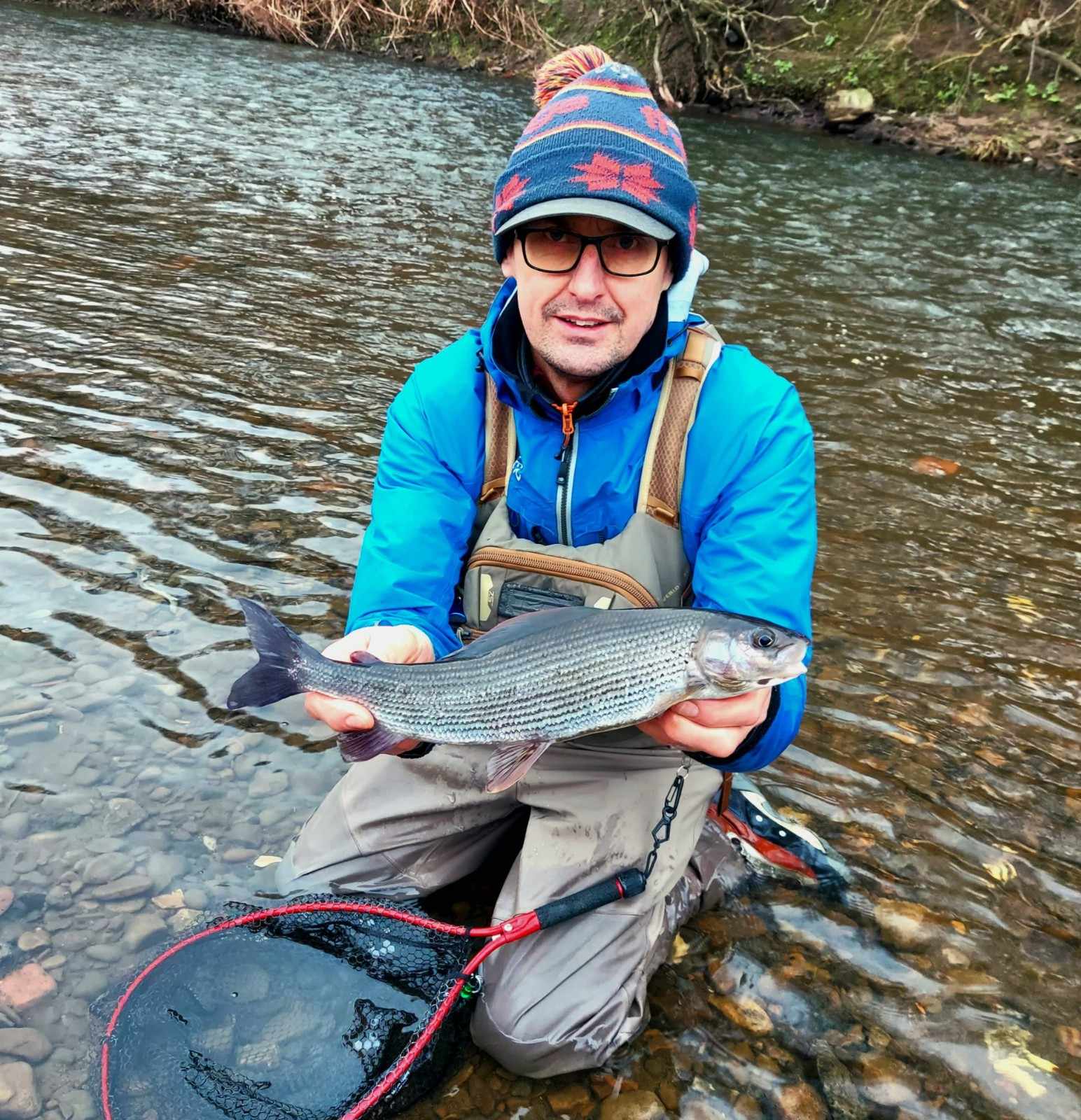 Man holding fish by river