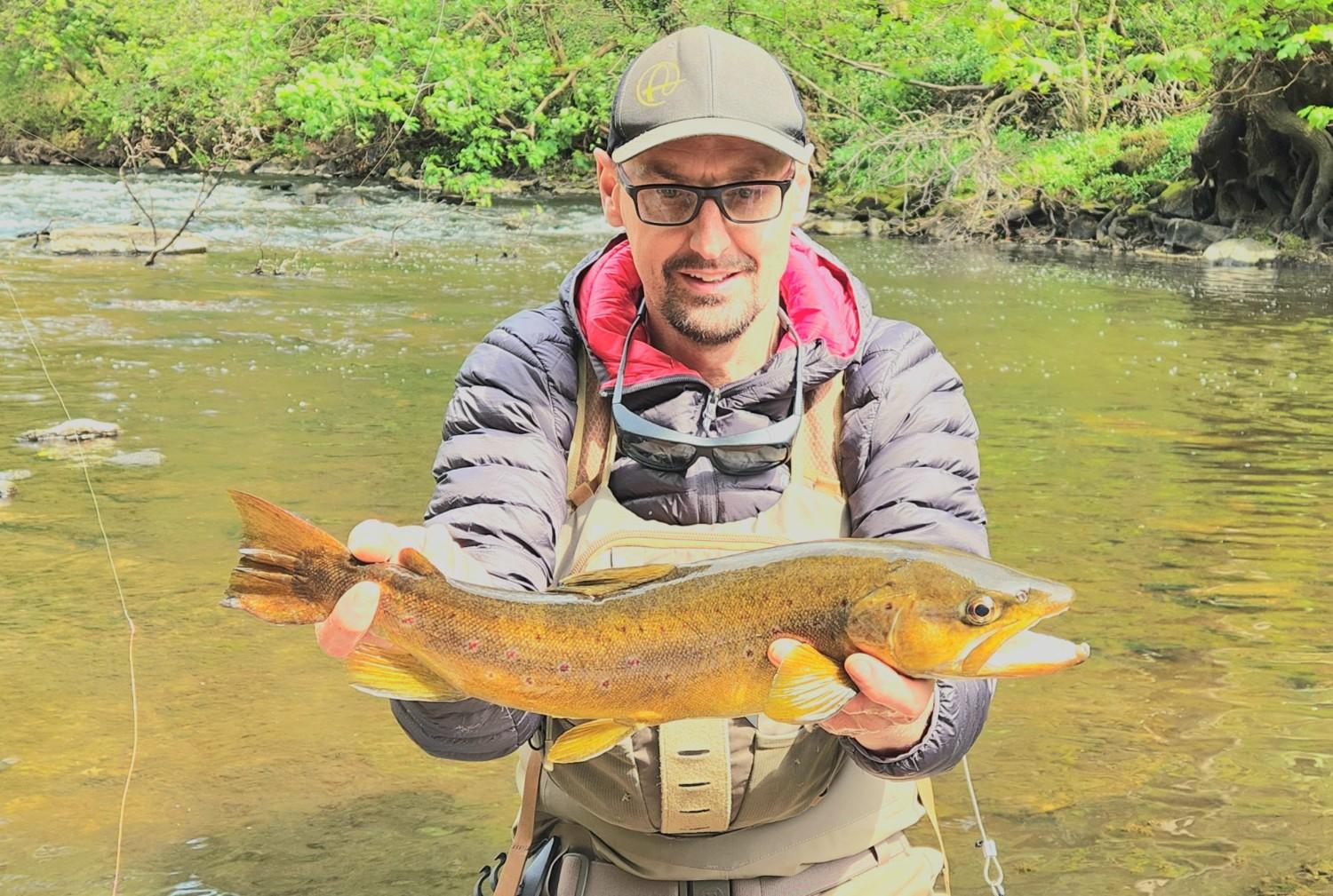 Person holding a trout fish